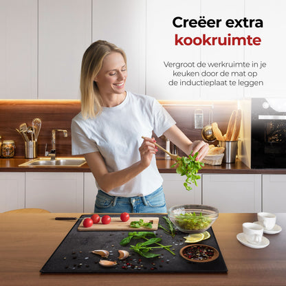 Vrouw in de keuken bezig met eten voorbereiden met behulp van de inductie beschermer kruiden en specerijen limoen